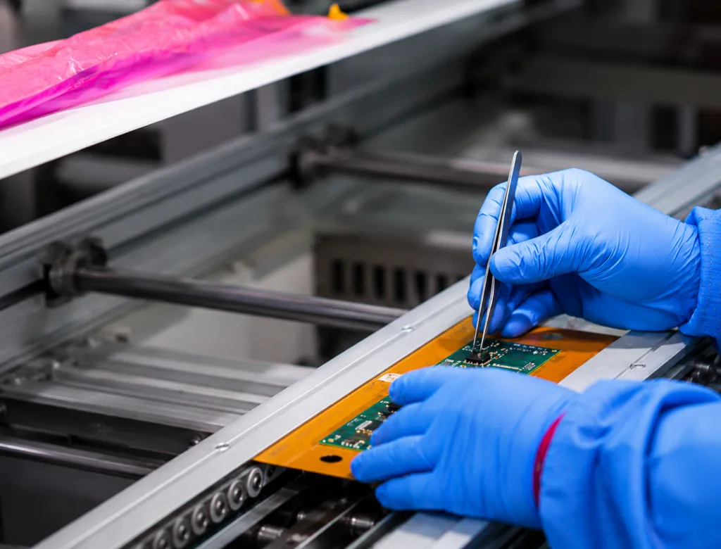 Technician inspecting a high Tg rigid PCB during production