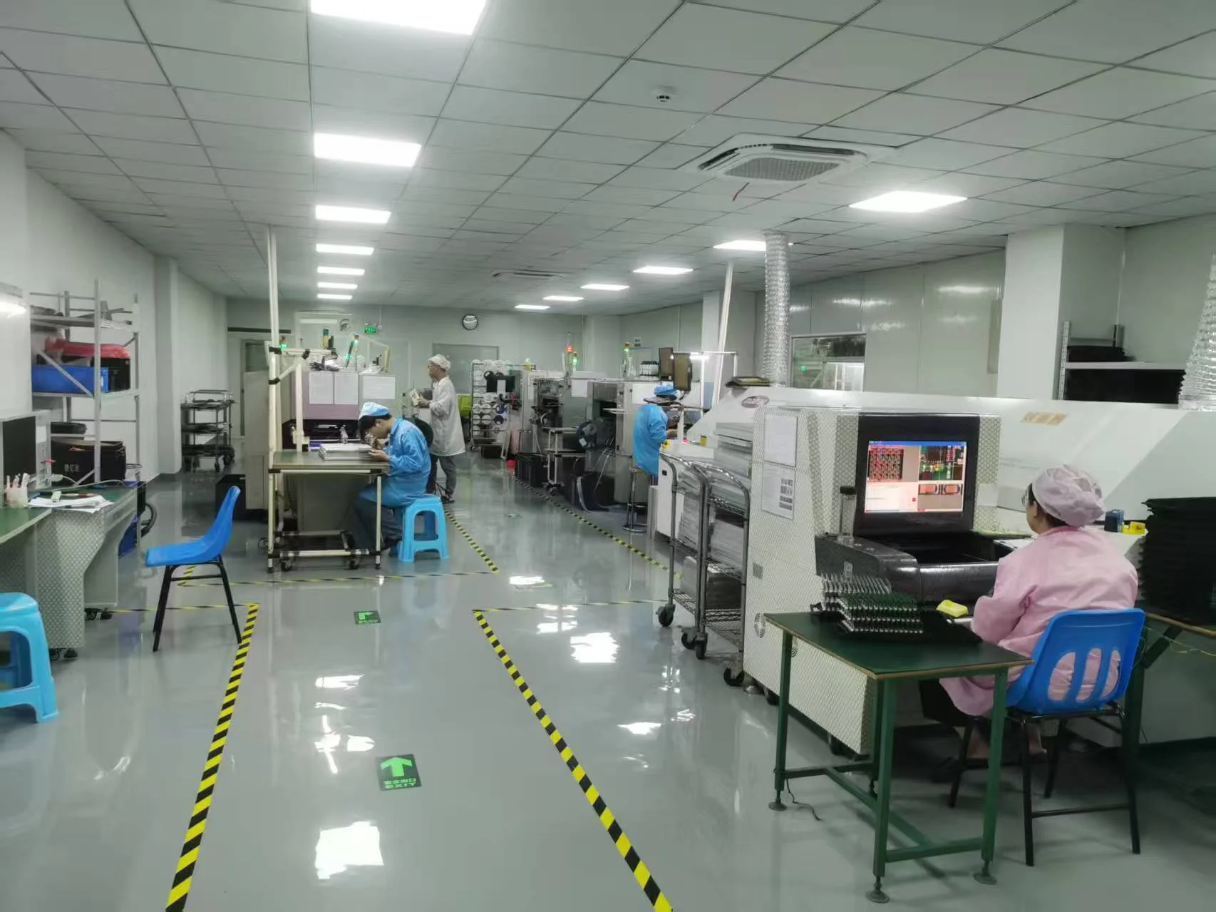 PCB assembly production floor with technicians and automated SMT equipment